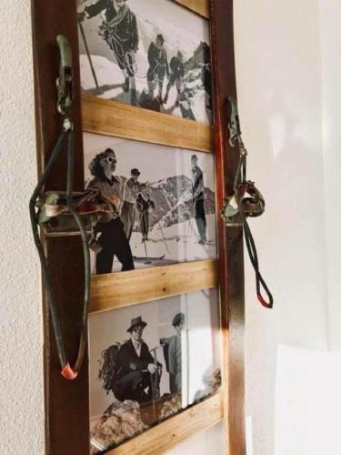 a wooden picture frame with pictures on a wall at M's Wood Appartement in Maishofen
