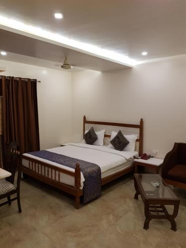 a bedroom with a bed and a couch and a table at Hotel Banaras Haveli in Varanasi