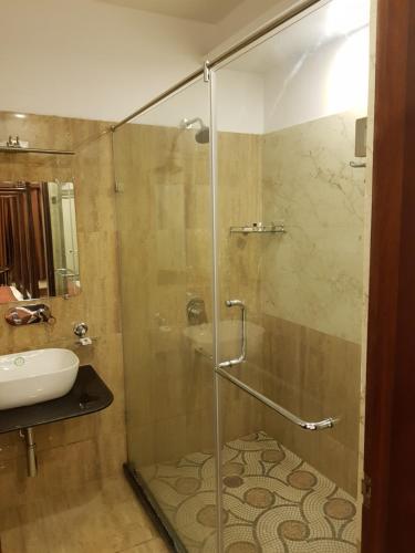a bathroom with a glass shower and a sink at Hotel Banaras Haveli in Varanasi