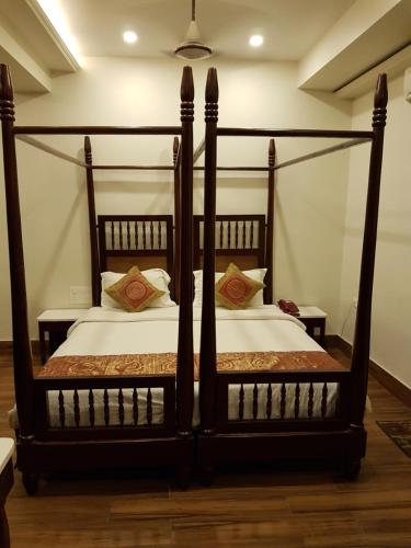 a bedroom with a four poster bed with white sheets at Hotel Banaras Haveli in Varanasi