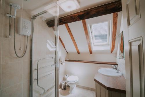 a bathroom with a shower and a toilet and a sink at The Stag Rooms in Stratford-upon-Avon