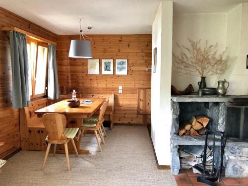 uma sala de jantar com uma mesa e uma lareira em Alpenchalet Trutmundi undri em Eischoll