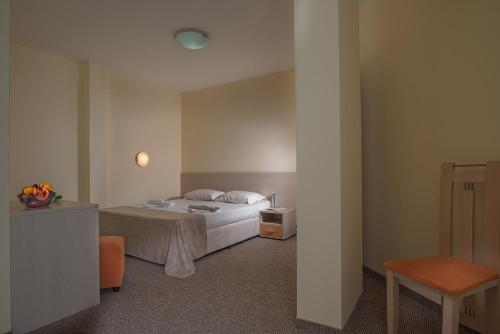 a bedroom with a bed and a table and a chair at Aparthotel Hotel Prestige City II in Primorsko