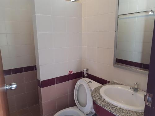 a bathroom with a toilet and a sink at Nathon Residence Hotel in Nathon