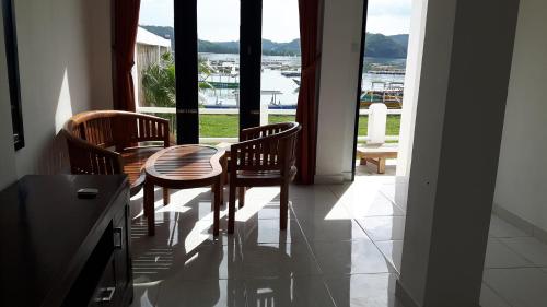 a dining room with a table and chairs and a window at Spear Beach House in Kuta Lombok