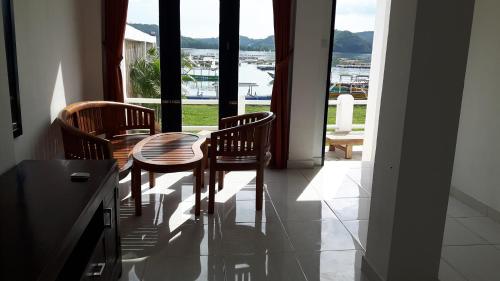 comedor con mesa, sillas y ventana en Spear Beach House, en Kuta Lombok