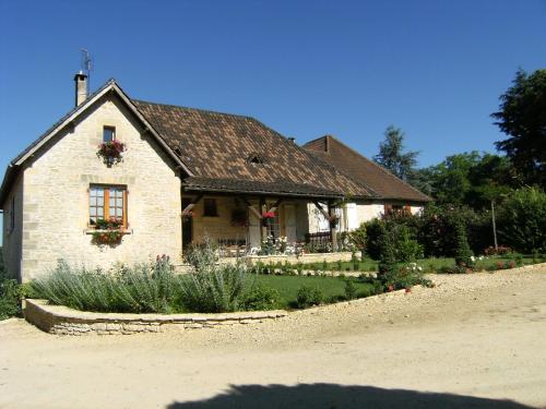 a house with a garden in front of it at Chambres d'Hôtes Larnaudie in Saint-Amand-de-Coly