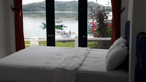 Cama en habitación con vistas al lago en Spear Beach House, en Kuta Lombok