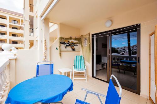 ロス・クリスティアーノスにあるPopular Complexの青いテーブルと椅子付きのバルコニーが備わる客室です。