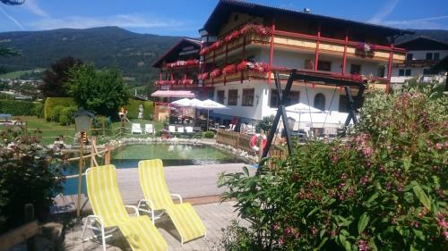 a hotel with two yellow chairs and a pool at Ferienhotel Gewürzmühle in Radstadt