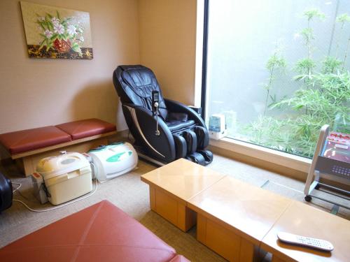 an office room with a suitcase sitting next to a window at Hotel Route-Inn Koga Ekimae in Koga