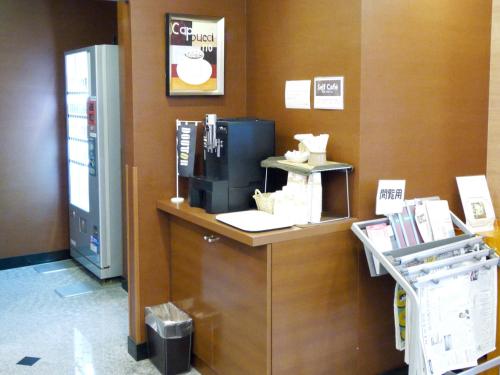 a cash counter in a store with a coffee machine at Hotel Route-Inn Koga Ekimae in Koga