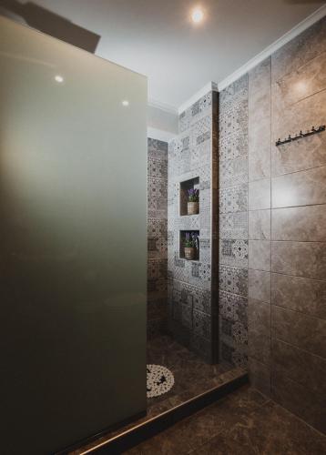 a bathroom with a shower with a glass door at Lenti Street House in Kallirákhi