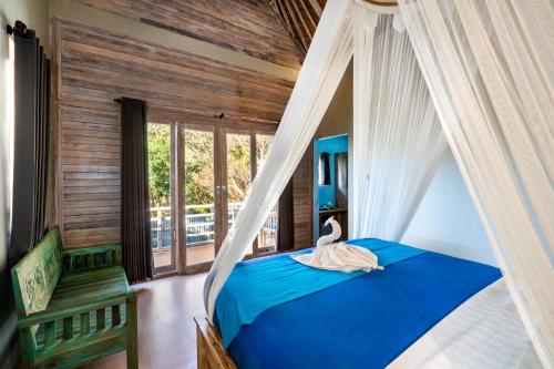 a bedroom with a canopy bed with a swan on it at Song Lambung Beach Huts in Nusa Lembongan