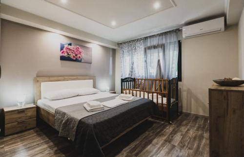 a bedroom with a bed and a crib in it at Lenti Street House in Kallirákhi