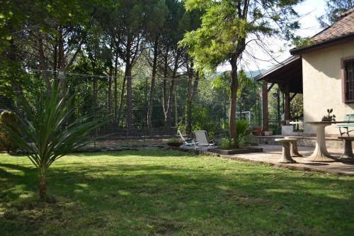 einen Garten mit einem Zaun, einem Tisch und Stühlen in der Unterkunft Etna Sweet Country in Pedara