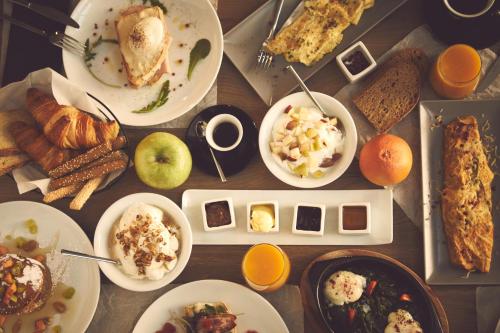 Una mesa con muchos platos de comida encima. en The Artist Athens, en Atenas