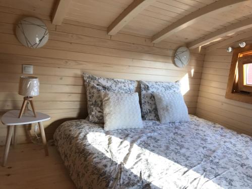 um quarto com uma cama num quarto de madeira em TINY HOUSE & SPA em Faycelles