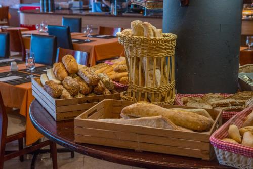 a table with trays of bread and baskets on it at Relaxia Lanzasur Club - Aqualava Water Park in Playa Blanca