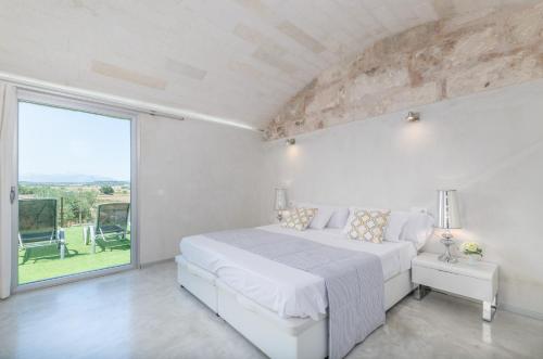 マリア・デ・ラ・サルにあるEs Gassonsのベッドと大きな窓のある白い寝室