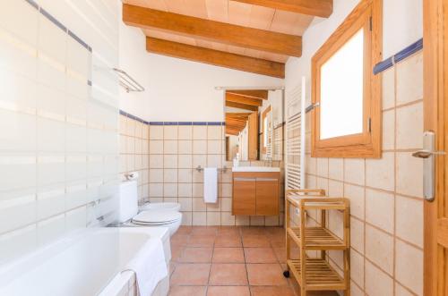 a bathroom with a tub and a toilet and a window at Finca Sa Plana in Son Servera