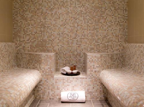 two beds in a room with a tile wall at La Côte Saint Jacques in Joigny