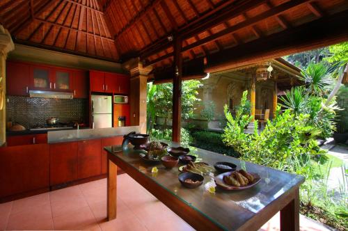 a kitchen with red cabinets and a wooden table at De Umah Bali Eco Tradi Home in Bangli
