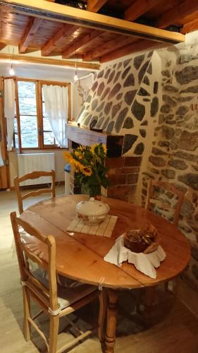 una mesa de madera en una habitación con una pared de piedra en La carole, en Mosset