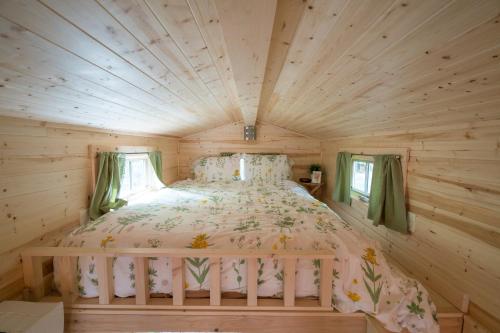 - une chambre dans une cabane en rondins avec un lit dans l'établissement Mount Hood Village Savannah Tiny House 4, à Welches