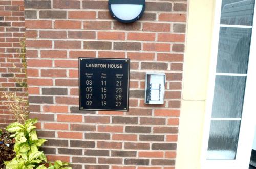 a sign on the side of a brick building at Home Crowd Luxury Apartments in Doncaster