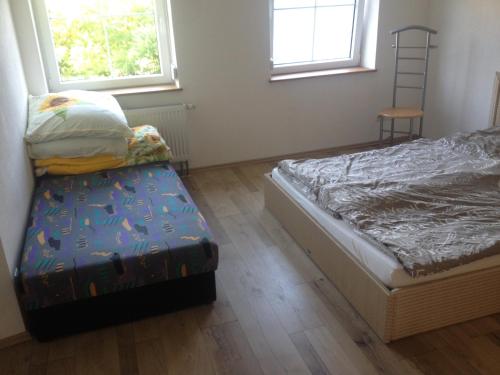 ヴァンゲン・イム・アルゴイにあるCarloのベッドルーム1室(ベッド1台、椅子1脚、窓2つ付)