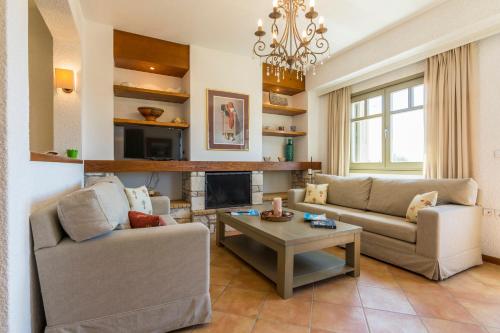 a living room with two couches and a fireplace at Elaia Villas in Pythagoreio