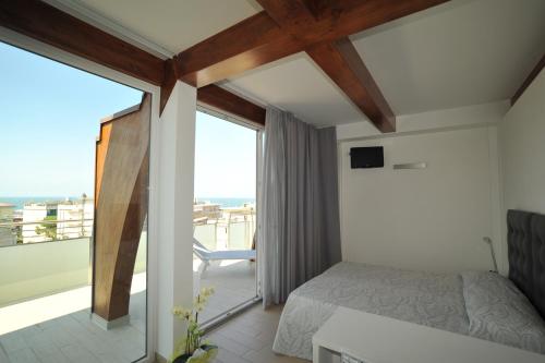 a bedroom with a bed and a large window at My Hotel in Gabicce Mare