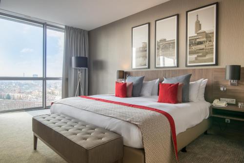 a hotel room with a large bed with red pillows at Bilderberg Parkhotel Rotterdam in Rotterdam