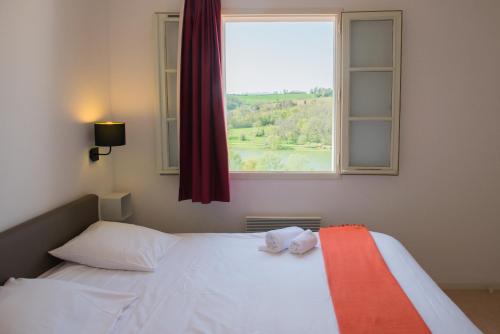 a bedroom with a white bed and a window at Résidence L'Oustal Del Carlat in Carla-Bayle