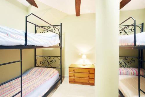 a bedroom with two bunk beds and a night stand at La Bodeguita in Benaocaz