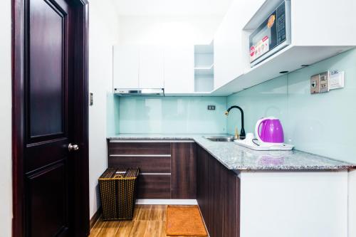 a kitchen with a sink and a counter top at AVA Hotel & Apartment in Danang
