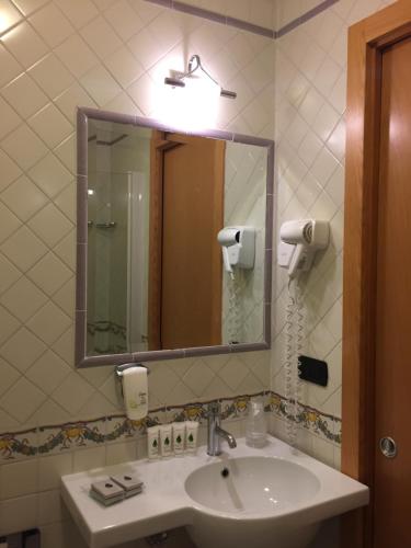 bagno con lavandino e grande specchio di Best Western Hotel Dei Cavalieri a Barletta