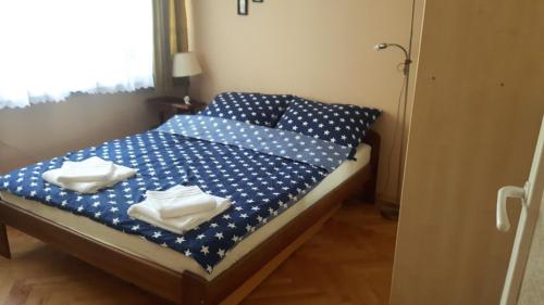 a bed with blue and white polka dot sheets and towels at motylek in Łódź