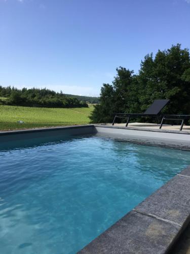 une piscine avec de l'eau bleue dans une cour dans l'établissement La Maison du Clos du Roi, à Mercurey