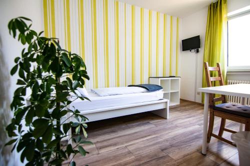 a bedroom with a bed and a potted plant at Landgasthof Hotel Will in Neuenstein