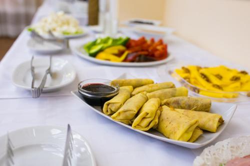 une table blanche avec des assiettes de nourriture dans l'établissement Vila Verde, à Chişinău