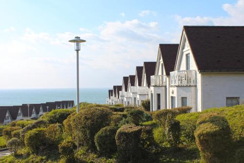 a row of houses on a hill next to the ocean at Evancy Equihen-Plage in Équihen-Plage