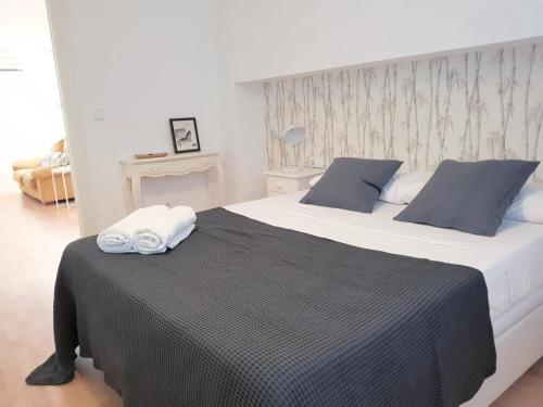 1 dormitorio con 1 cama grande con manta negra en FLORIT FLATS - The Jardines del Turia Apartment en Valencia