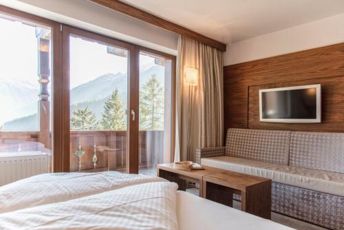 a bedroom with a bed and a tv and a window at die Aussicht in Finkenberg