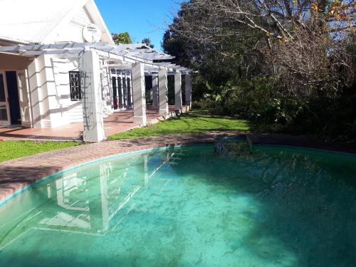 a swimming pool in the yard of a house at SARAH's PLACE- MANOR HOUSE in George