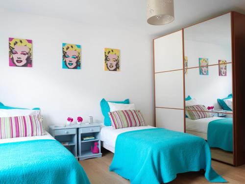 シャモニー・モンブランにあるAran Apartment - Chamonixのベッドルーム1室(青いシーツと鏡付きのベッド2台付)