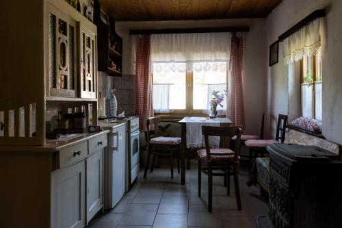 cocina con mesa, sillas y ventana en Apartment Eko Etno selo Stara Kapela, Pavina kuća en Stara Kapela