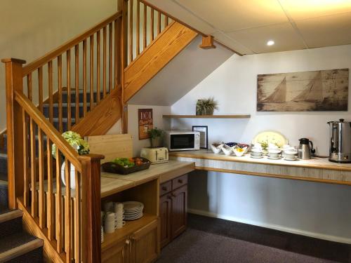 a kitchen with a counter and a staircase at Redwings Lodge Rutland in Uppingham