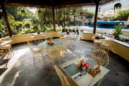 a restaurant with tables and chairs and a pool at Park Village Resort by KGH Group in Kathmandu